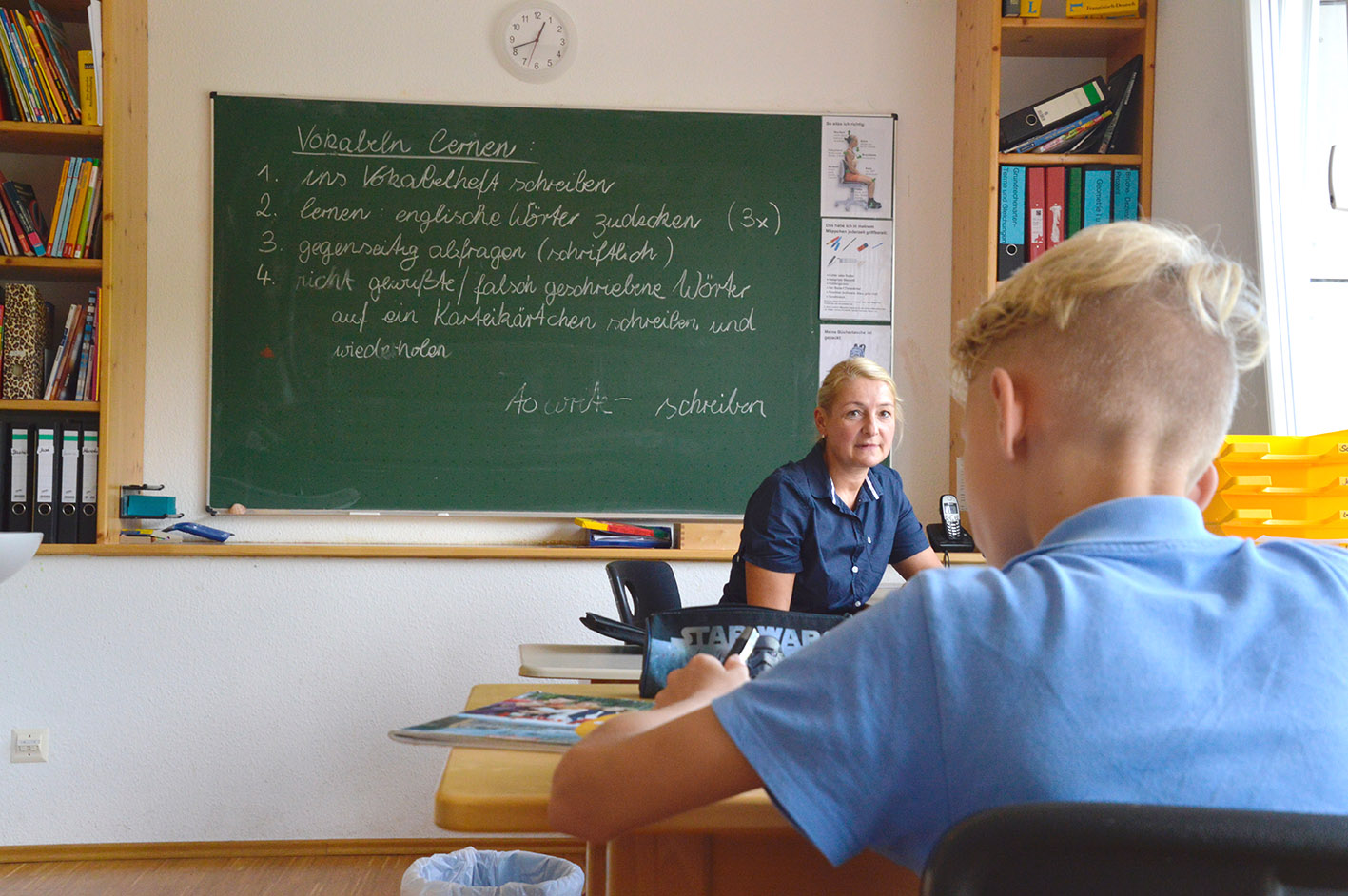 Schüler und Lehrerin im Klassenzimmer mit Tafel